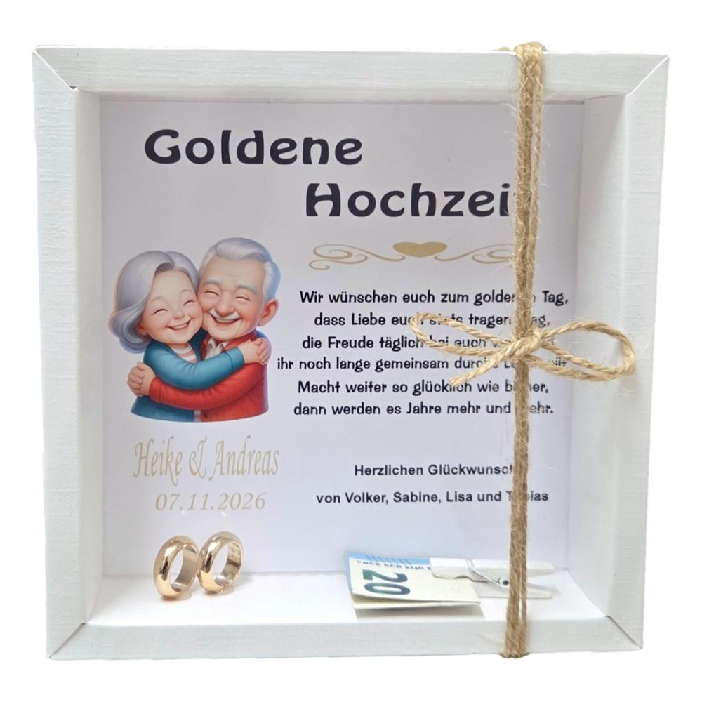 Weiße Geschenkbox zur Goldenen Hochzeit mit personalisiertem Hintergrund, älterem Ehepaar, goldenen Ringen und kleiner Holzklammer für Geldgeschenke.