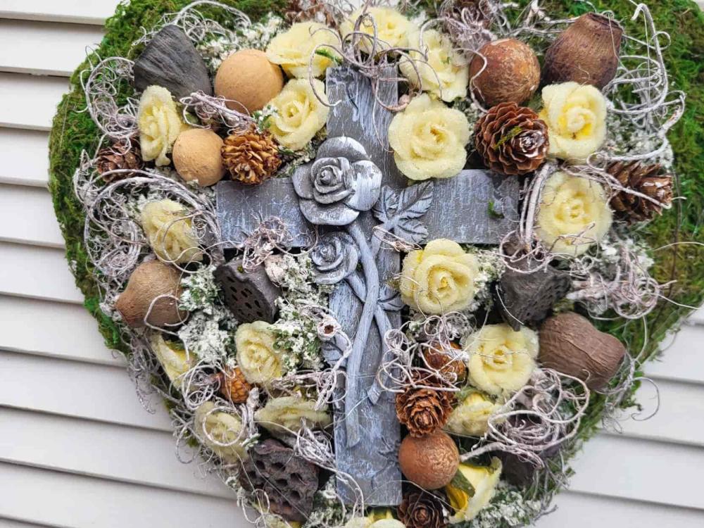 Grabherz aus Moos und vielen kleinen  Rosen und einem großen Kreuz in der Mitte