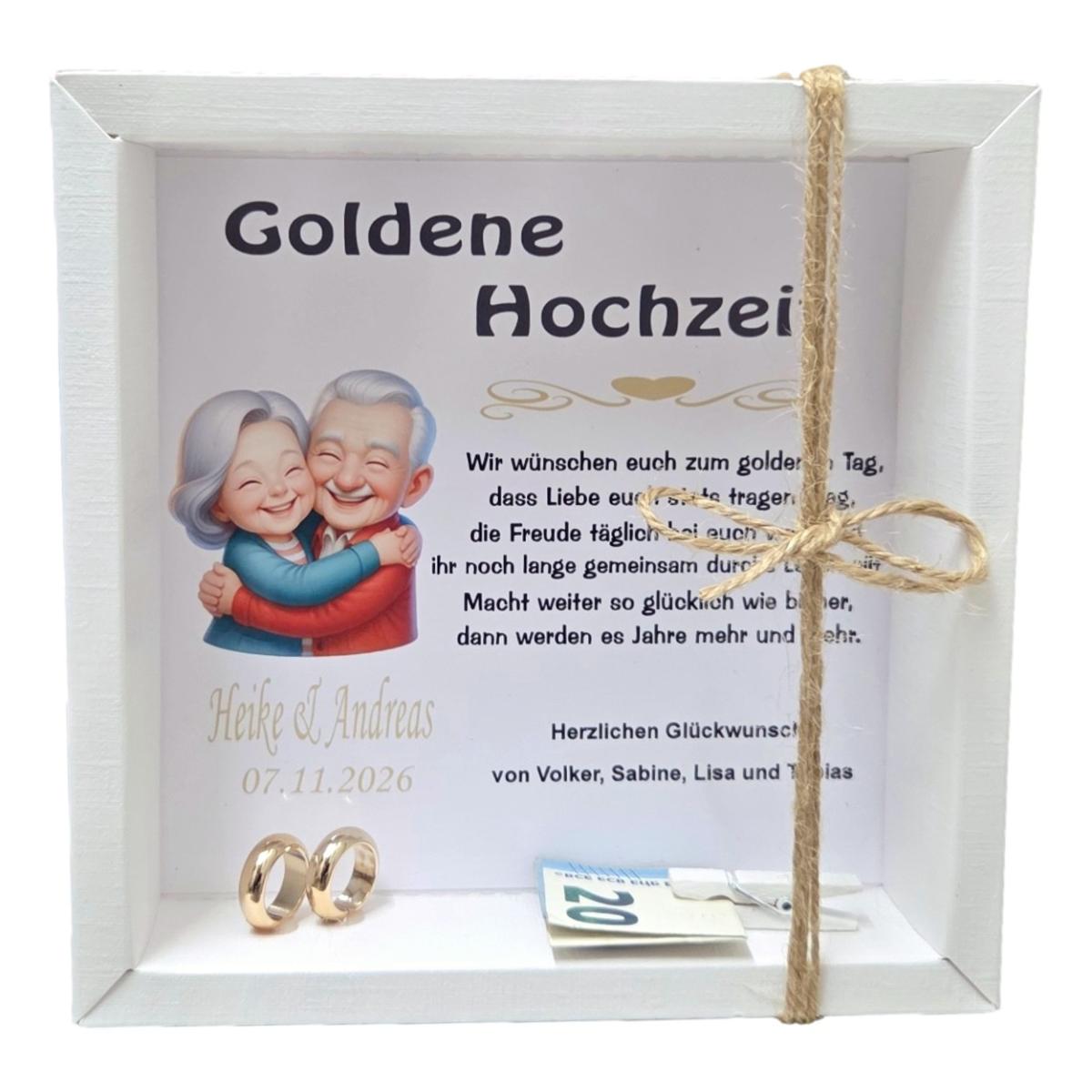 Weiße Geschenkbox zur Goldenen Hochzeit mit personalisiertem Hintergrund, älterem Ehepaar, goldenen Ringen und kleiner Holzklammer für Geldgeschenke.